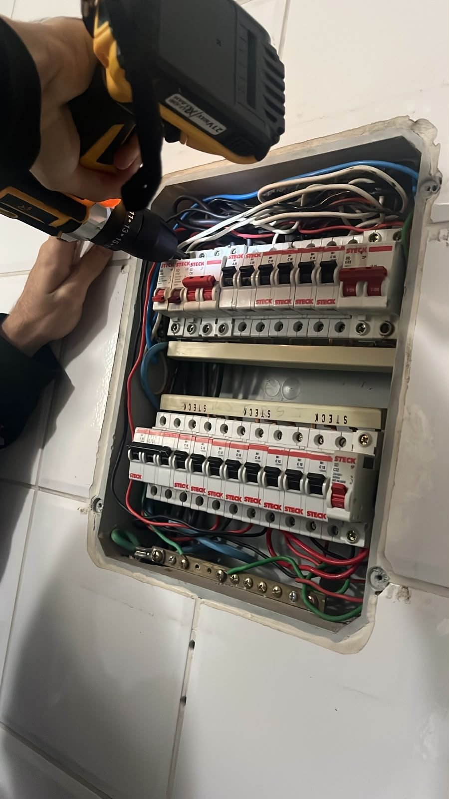 Furadeira e disjuntor durante instalação elétrica pela rede RMT