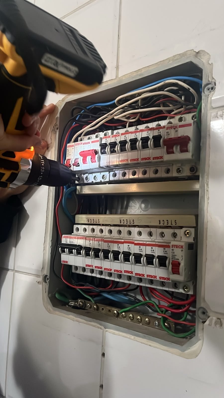 Eletricista parceiro da RMT apertando parafuso de disjuntor