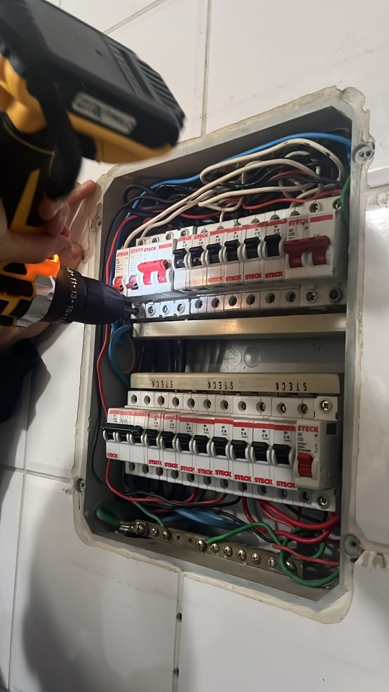 Eletricista da RMT trabalhando em quadro de disjuntores residencial